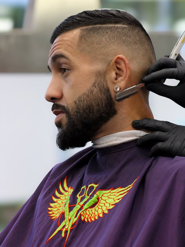 Barber finishing a client's neckline with a straight razor