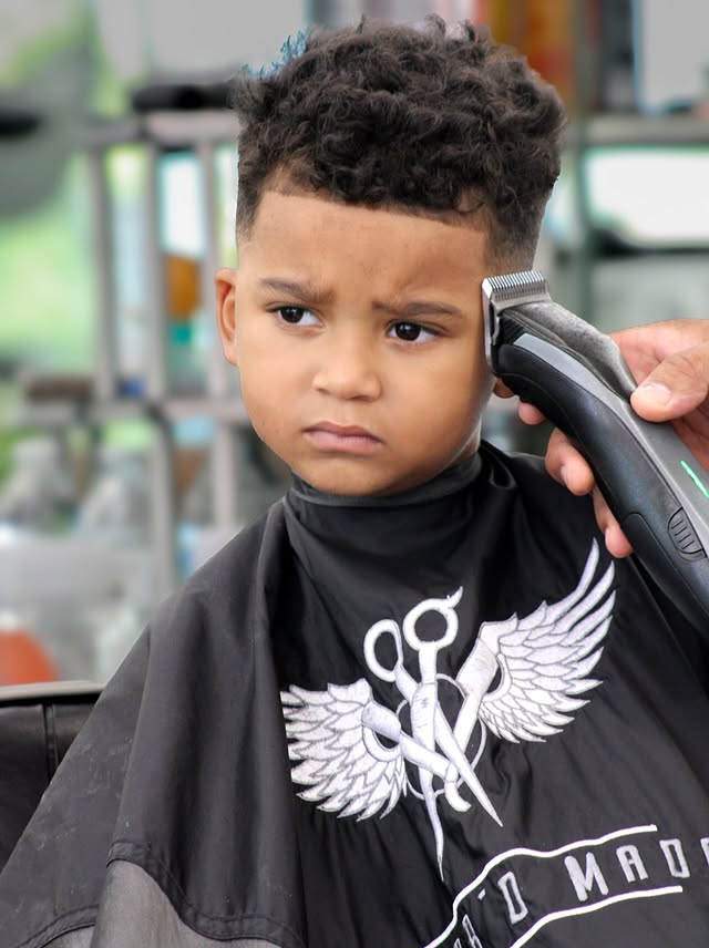 Young client getting a kids' haircut in the barber chair